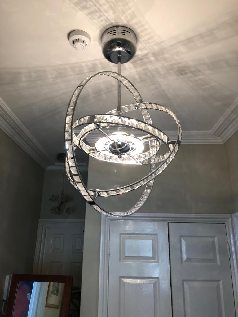 Modern orbital ceiling pendant installed in period hallway